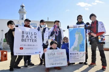 東日本大震災の被災地を巡る旅のスタート地点で、記念撮影する「世界防災フォーラム」の関係者ら＝23日午前、福島県いわき市の塩屋埼灯台