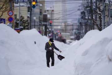 札幌市内で除雪作業をする男性＝23日