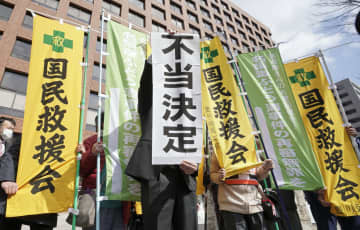 再審開始を認めない決定に、名古屋高裁前で「不当決定」と書かれた紙を掲げる弁護士＝3日午前