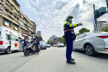 台湾の大規模停電で交通整理する警察官＝3日、台北（中央通信社＝共同）