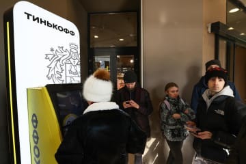 現金自動預払機（ATM）から現金を引き出すために並ぶ人たち＝2日、モスクワ（タス＝共同）