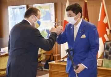 会談を前にウクライナのコルスンスキー駐日大使（左）とタッチする岸防衛相＝9日午前、防衛省