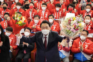 10日、韓国大統領選に勝利し花束を手にする「国民の力」の尹錫悦氏＝ソウル（共同）