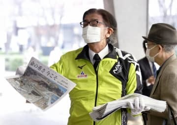 JR有楽町駅前で、特別号外を配布する岩手日報社の東根千万億社長＝11日午前