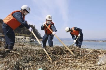 岩手県陸前高田市の沿岸で行方不明者の手掛かりを求めて捜索する大船渡署員ら＝11日午前10時23分