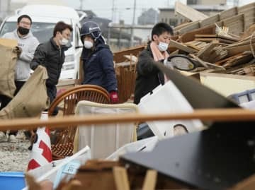 福島県相馬市で災害ごみを運び込む人たち＝19日午後