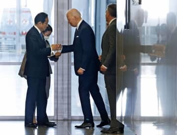 24日、NATO本部で米国のバイデン大統領と拳を合わせる岸田首相（左）＝ブリュッセル（共同）