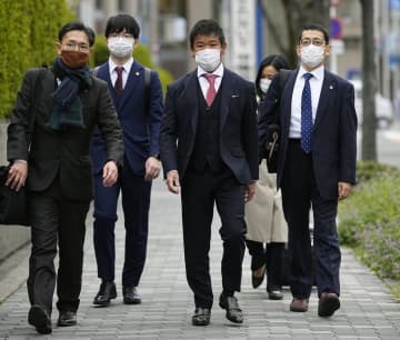 提訴のため、大阪地裁に向かうプレサンスコーポレーションの山岸忍前社長（中央）ら＝29日午前