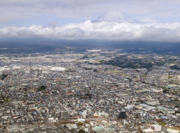 富士山（奥）と静岡県富士宮市の市街地。「富士山火山防災対策協議会」は噴火に備えた避難計画を部分改定する中間報告書を公表した＝30日午後（共同通信社ヘリから）