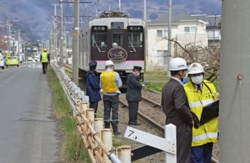 電車と軽乗用車が衝突した現場付近を調べる捜査員ら＝5日午前11時24分、福島市飯坂町