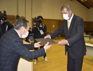くじ引きで当選が決まり、当選証書を受け取る北山太加視氏（右）＝8日午後、三重県伊賀市