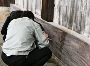 東大寺大仏殿で、液体のようなものがかけられた跡を確認する文化庁の職員ら＝15日午後、奈良市
