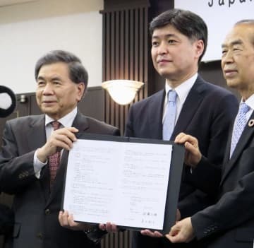 立地協定を結び、記念撮影に応じる「JASM」の堀田祐一社長（中央）ら＝19日午後、熊本市