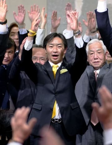 参院石川選挙区補選で当選を確実とし、万歳する宮本周司氏（中央）＝24日夜、金沢市