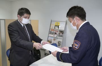 山口県美祢市消防本部に公務災害の認定を求める申請書を提出する、竹田勇二さんの両親の代理人弁護士（左）＝26日午前