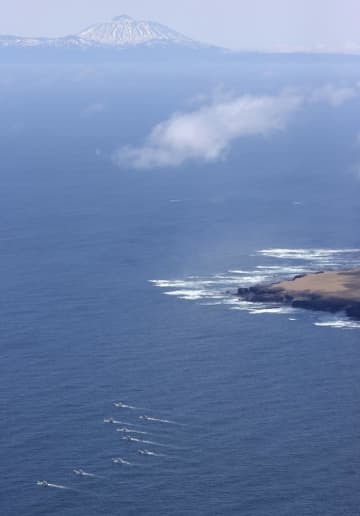 4月30日、北海道・知床半島沖で捜索する漁船団（左下）。奥は国後島（共同通信社ヘリから）
