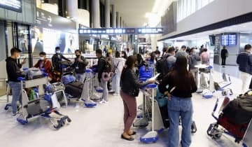 成田空港の到着ロビーに出て、検疫中の家族や友人を待つ入国者ら＝4月7日