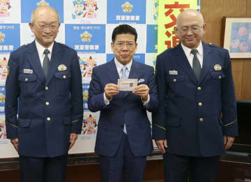 運転免許を自主返納し、大阪府警箕面署から運転経歴証明書を受け取った漫才師の西川きよしさん（中央）＝11日午後、大阪府箕面市