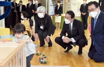 子育て交流サロンを視察する岸田首相（右から2人目）。右端は後藤厚労相＝12日午前、東京都中央区（代表撮影）