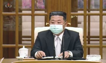 朝鮮労働党の政治局会議の冒頭、マスクを着けて臨む金正恩総書記。北朝鮮の朝鮮中央テレビが12日放映した（共同）