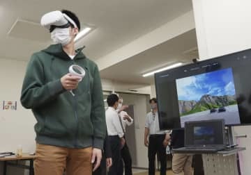 VR横断歩行シミュレーターを体験する滋賀大の学生＝4月、滋賀県彦根市