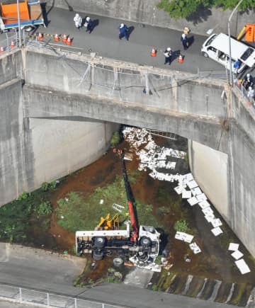 トンネル点検の準備中に、土砂をためる池に転落した作業車＝16日午後2時46分、広島市西区（共同通信社ヘリから）