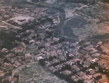 1945年3月23日、沖縄県の渡嘉敷村が米軍機の機銃掃射を受ける映像の一場面（豊の国宇佐市塾提供）