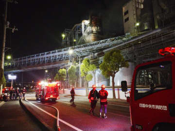 火災が発生した大王製紙三島工場で消火活動する消防団員ら＝23日夜、愛媛県四国中央市