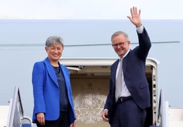 23日、日本に向かう飛行機に乗り込むアルバニージー首相（右）とウォン外相＝オーストラリア首都キャンベラ（ゲッティ＝共同）