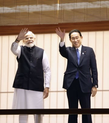 迎賓館の池のコイに餌を与え、笑顔を見せる岸田首相（右）とインドのモディ首相＝24日午後、東京・元赤坂