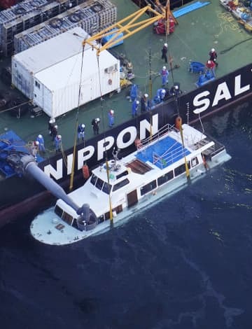 海面上までつり上げられた観光船「KAZU　1」＝26日午後6時54分、北海道斜里町沖（共同通信社ヘリから）