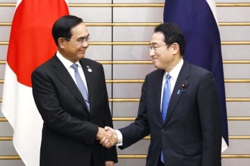 会談を前に握手するタイのプラユット首相（左）と岸田首相＝26日午後、首相官邸