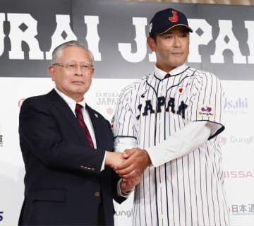 2017年7月、野球日本代表の稲葉篤紀監督（右）と握手する日本野球協議会の熊崎勝彦会長＝東京都内のホテル