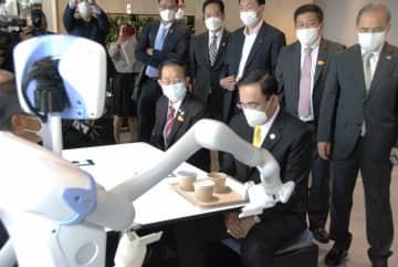 ロボットが配膳するレストランを視察する、タイのプラユット首相（手前）＝27日午後、東京都大田区の羽田イノベーションシティ