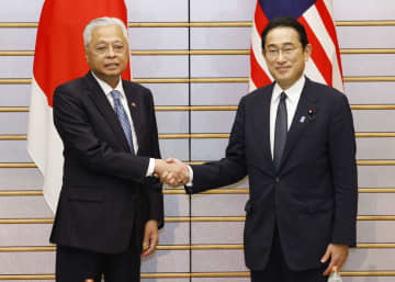 会談を前に握手するマレーシアのイスマイルサブリ首相（左）と岸田首相＝27日午後、首相官邸