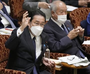参院予算委で答弁のため挙手する岸田首相＝30日午後