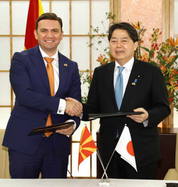 経済交流の強化を図る技術協定に署名し、握手する北マケドニアのオスマニ外相（左）と林外相＝30日午後、外務省