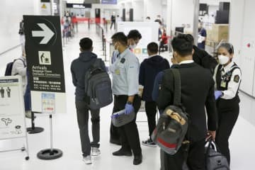 成田空港に到着し、検疫検査場へ向かう人たち＝1日午前
