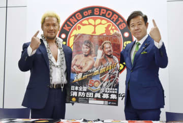 消防団員募集のポスターを手にする新日本プロレスの真壁刀義選手（左）と田畑裕明総務副大臣＝1日午後、東京都中野区