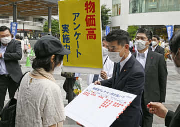 JR有楽町駅前でボードを持ち、物価高騰について調査する立憲民主党の泉代表（手前右）＝3日午後