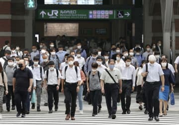 東京駅前をマスク姿で通勤する人たち