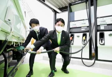 給油所で次世代バイオディーゼル燃料をPRするユーグレナの出雲充社長（右）ら＝10日午前、名古屋市