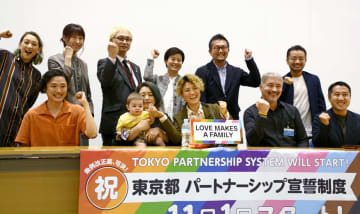 「東京都パートナーシップ宣誓制度」を盛り込んだ改正都人権条例が成立したことを受け、記者会見で喜ぶ杉山文野さん（後列右端）ら＝15日午後、東京都庁