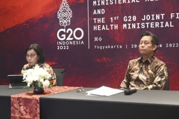 21日、G20財務相・保健相合同会合後に開かれた記者会見で話すインドネシアのムルヤニ財務相（左）＝ジョクジャカルタ（共同）