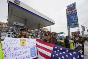 ガソリンスタンドの前でガソリン価格高騰に抗議する人々＝4日、米ロサンゼルス（AP＝共同）