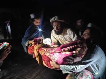 22日、アフガニスタン東部パクティカ州で、地震の負傷者を避難させる人々（Bakhtar　News　Agency提供、AP＝共同）