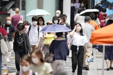 猛烈な暑さの中、JR浦和駅前を行き交う人たち＝26日午前、さいたま市