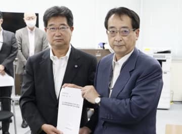 経産省の松永明参与（右）に決議を手渡す全漁連の坂本雅信会長＝27日午前、経産省
