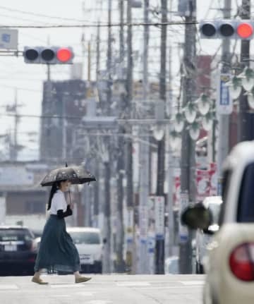 梅雨明けしたとみられる栃木県佐野市で、猛暑の中を歩く女性＝27日午後