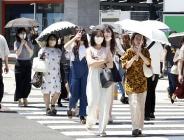 猛暑の中、東京・表参道を歩く人たち＝30日午後